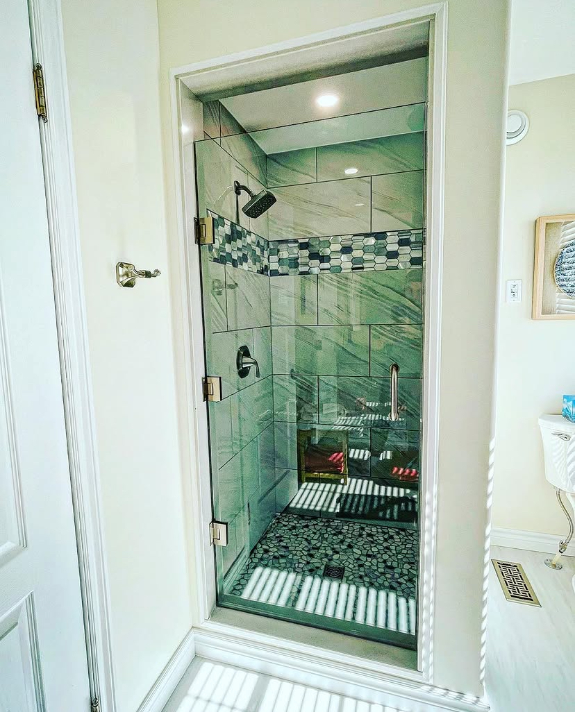 Frameless shower glass with black hardware and marble tile