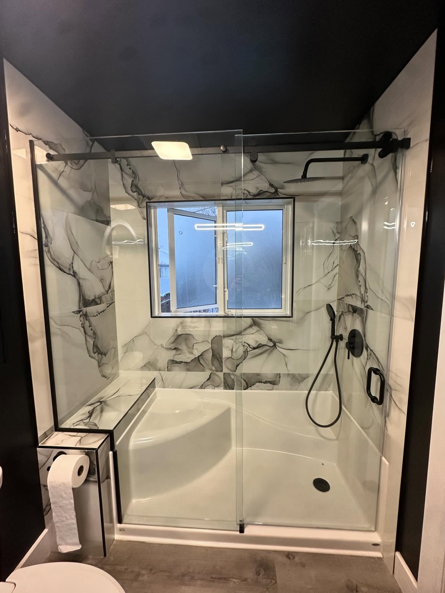 Sliding glass shower enclosure with black rail hardware