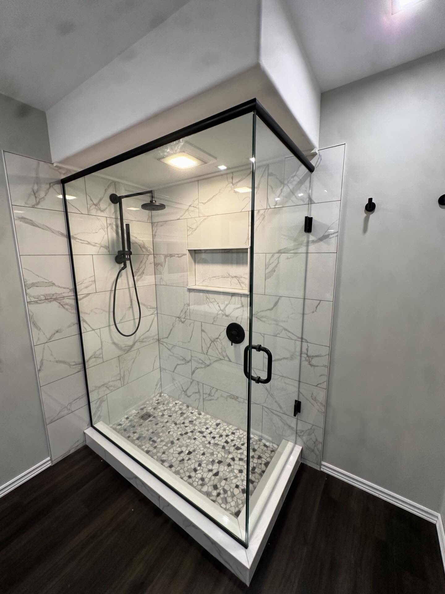 Clear corner glass shower enclosure with black hardware